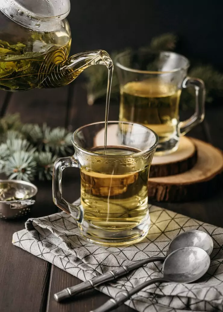 high-angle-hand-pouring-tea-glass